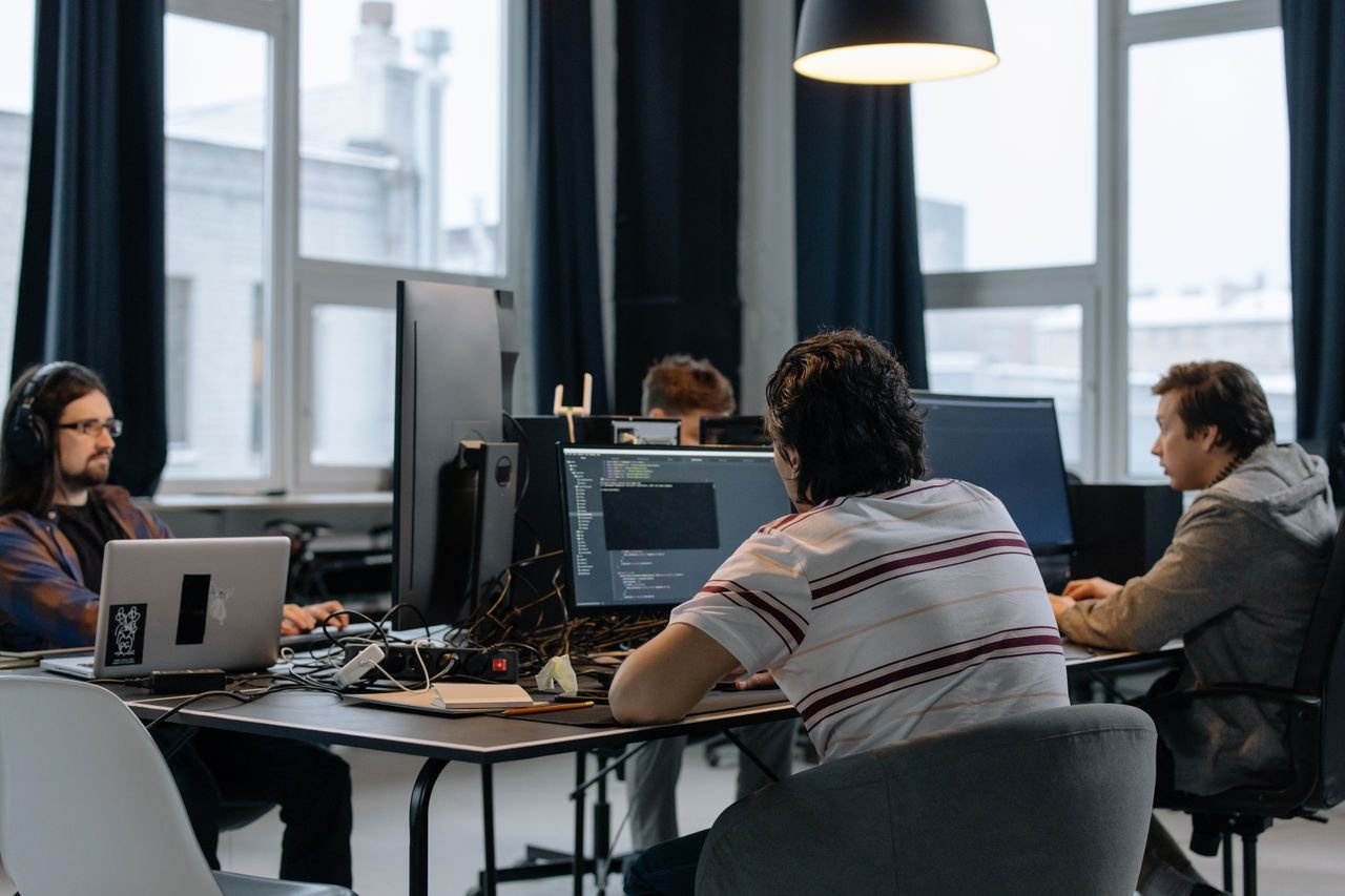 Mastering the First Impression: Your intriguing post title goes here Team of developers working together on computers in a modern tech office.